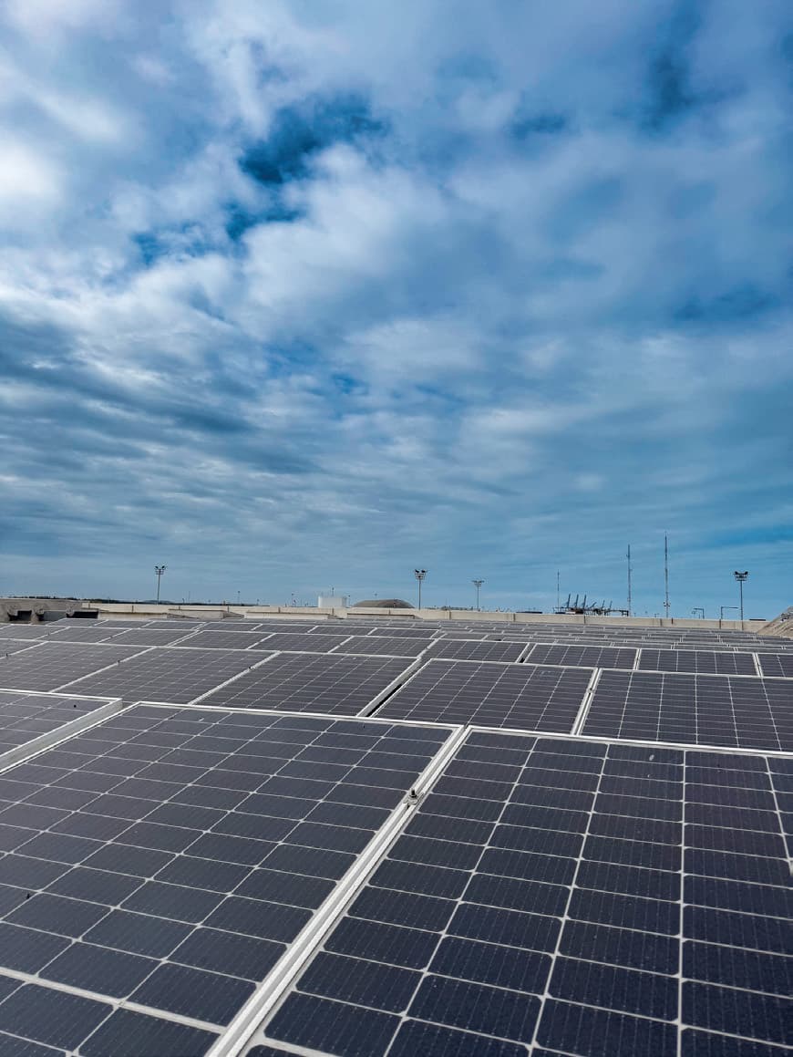 Arreglo de paneles solares vistos desde abajo contra un cielo despejado.